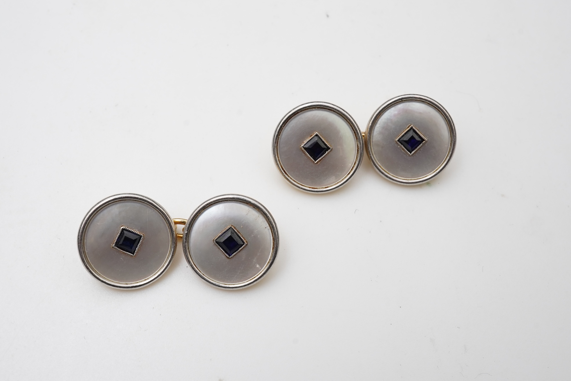 A pair of mother of pearl and sapphire cufflinks, early 20th century